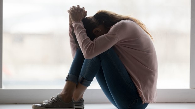 Depressed sad teen girl sit on sill crying alone at home upset desperate young woman feeling frustrated anxious regret mistake suffer from unwanted teenage pregnancy abortion problem concept